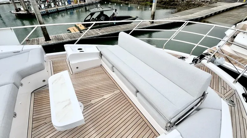 Slide: The Image of Azimut Fly 60 2024 yacht deck with seating and wooden flooring at marina. - 46