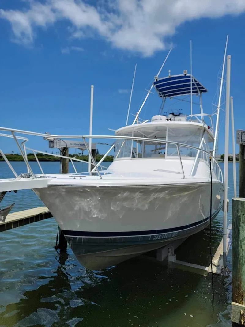 The Image of 1997 Luhrs 32 Open boat docked under clear blue sky. - 0