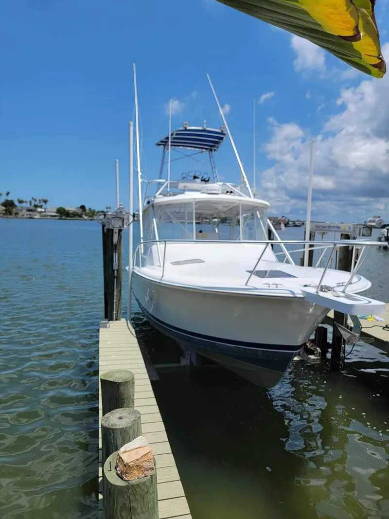 Slide: The Image of 1997 Luhrs 32 Open boat docked on a sunny day, clear blue sky. - 1