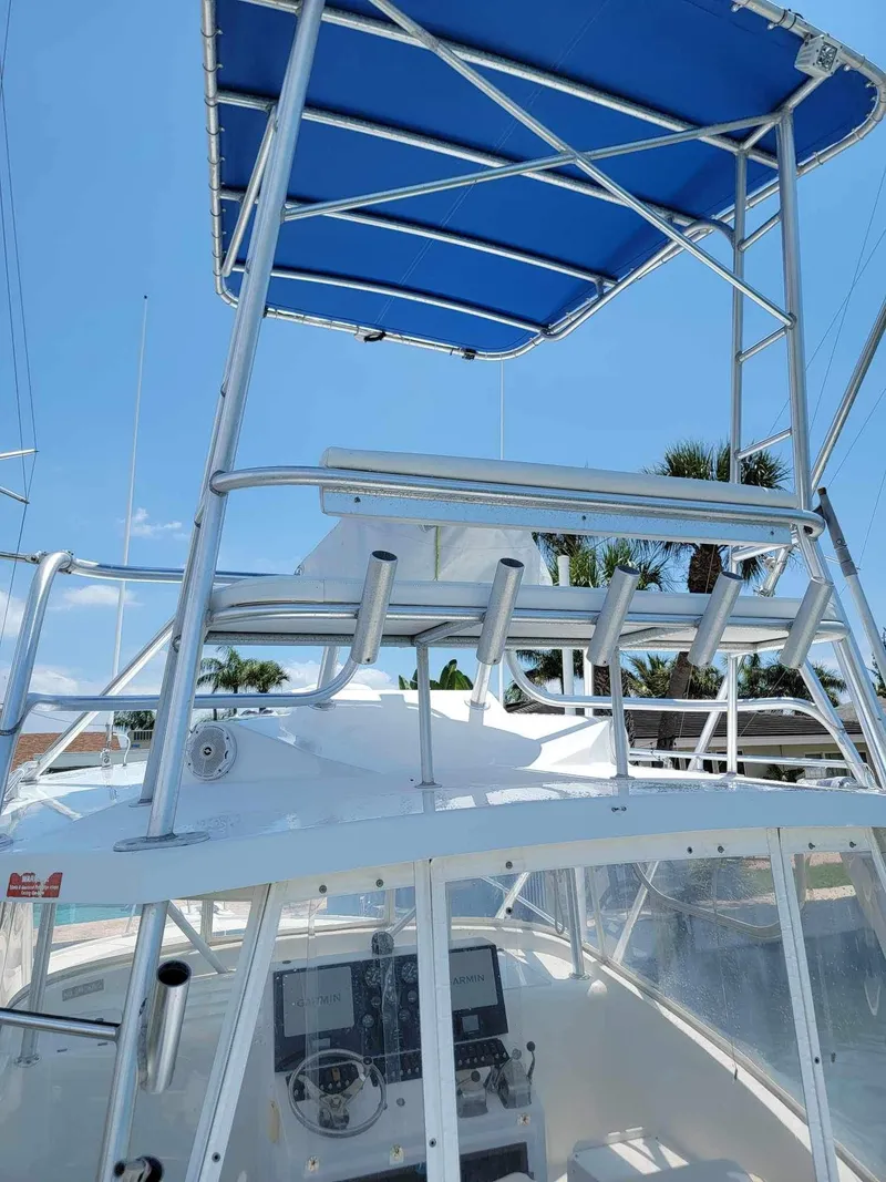 Slide: The Image of 1997 Luhrs 32 Open boat with blue canopy and fishing rod holders. - 12