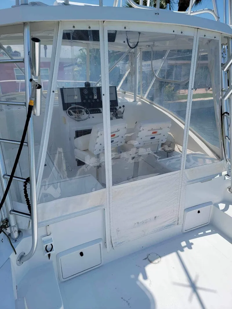 Slide: The Image of 1997 Luhrs 32 Open boat cockpit with helm and seating, enclosed by clear panels. - 13