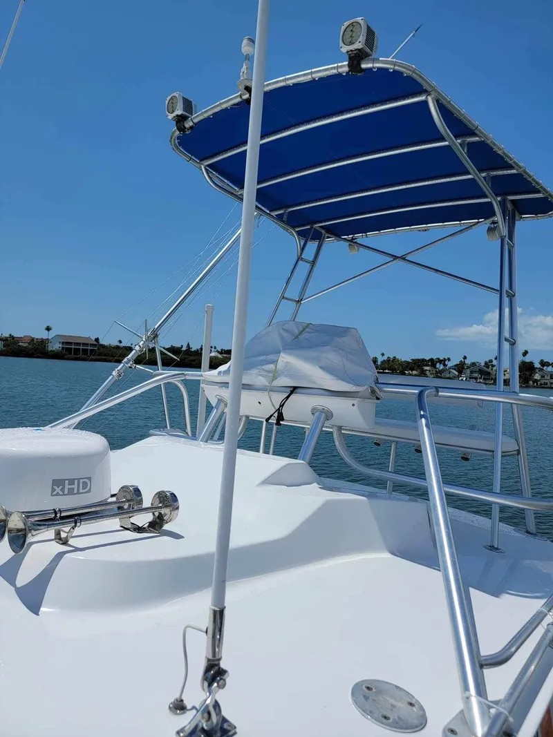 Slide: The Image of 1997 Luhrs 32 Open boat with blue canopy, docked on a sunny day. - 18