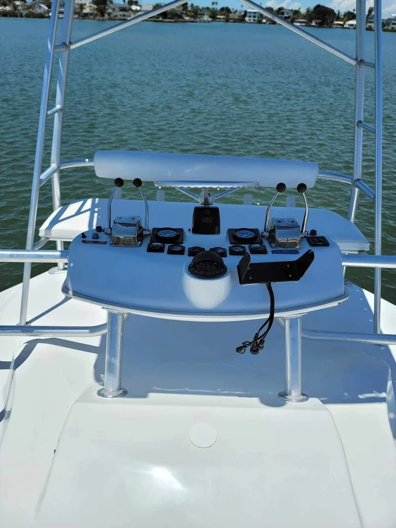 Slide: The Image of 1997 Luhrs 32 Open boat helm with controls and gauges on a sunny day. - 24