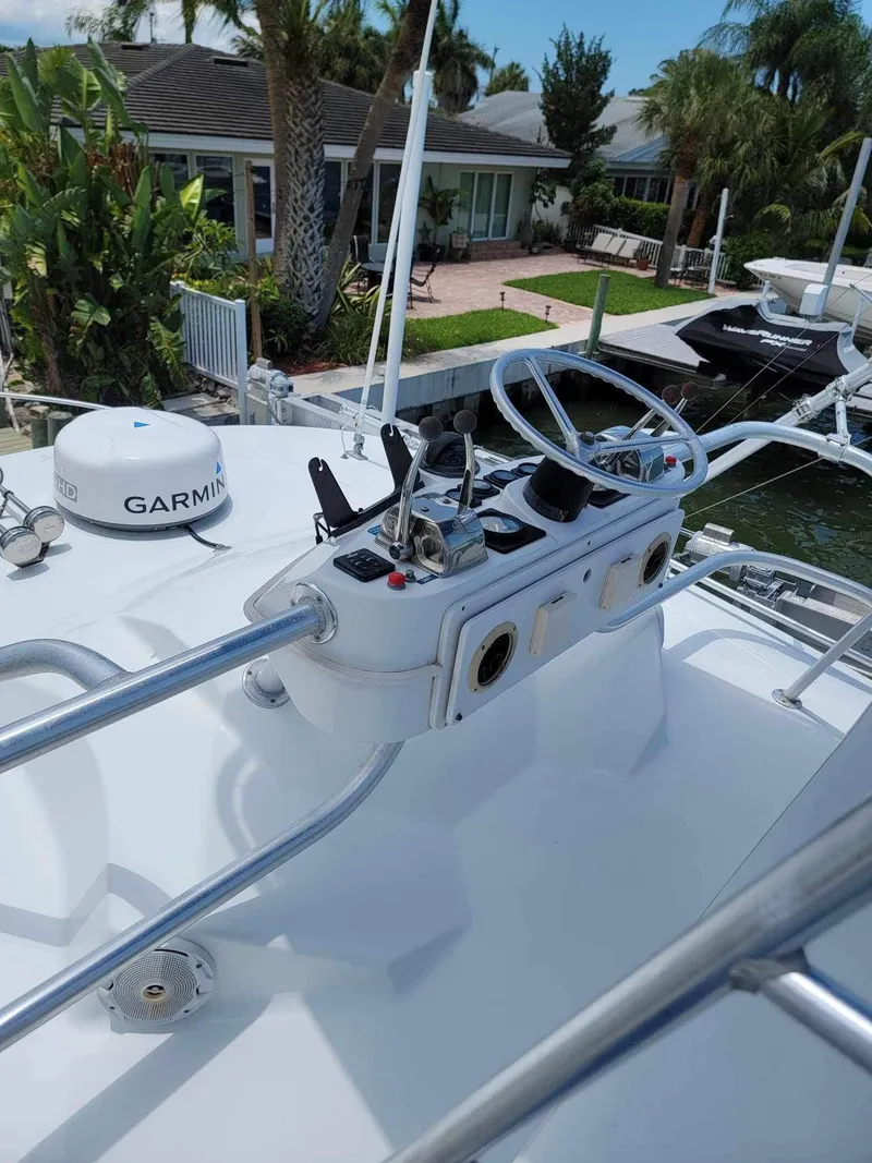 Slide: The Image of 1997 Luhrs 32 Open boat helm with Garmin equipment, docked near waterfront homes. - 26