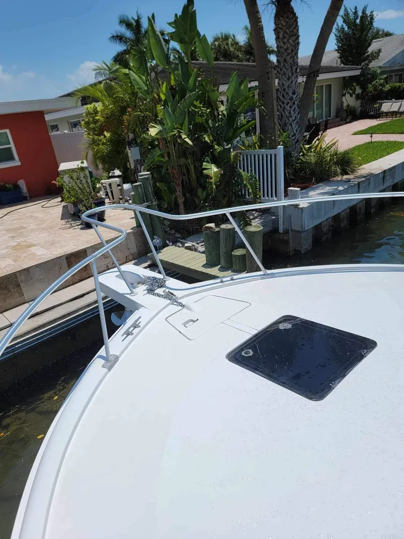 Slide: The Image of Bow of a 1997 Luhrs 32 Open boat docked near a tropical garden. - 31