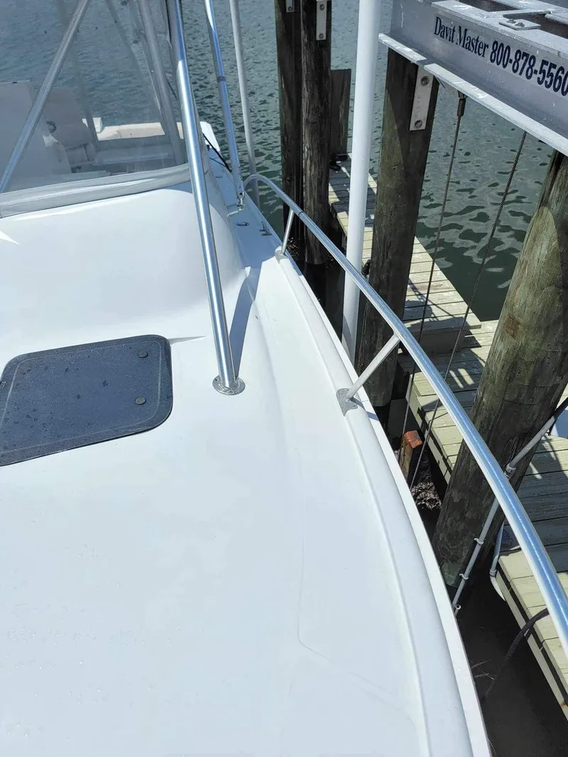Slide: The Image of 1997 Luhrs 32 Open boat deck near dock, featuring railing and hatch. - 37