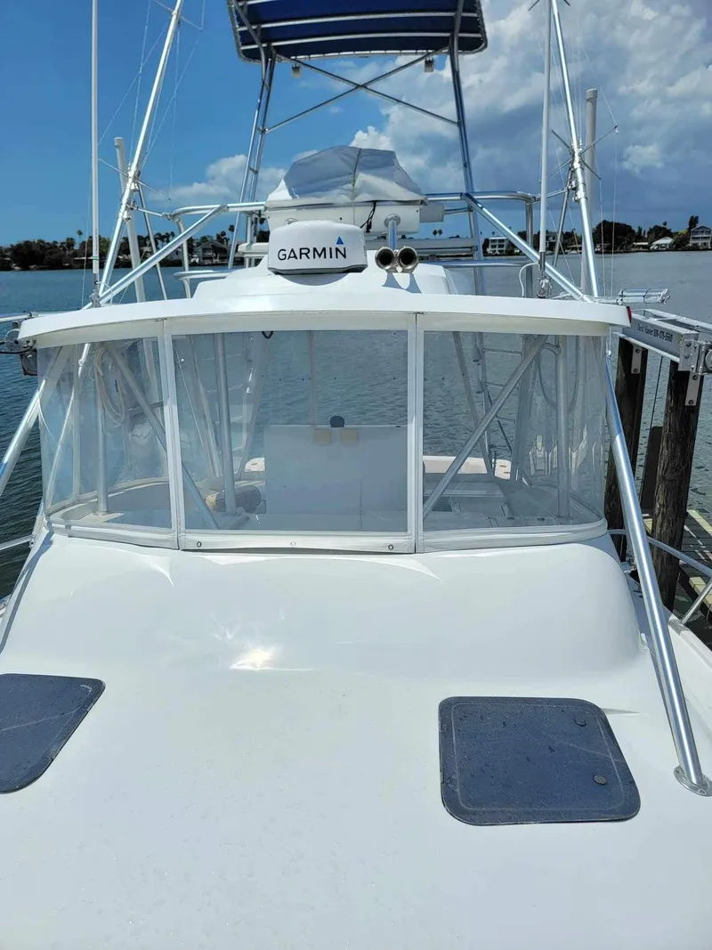 Slide: The Image of 1997 Luhrs 32 Open boat with Garmin equipment, docked under a clear blue sky. - 38