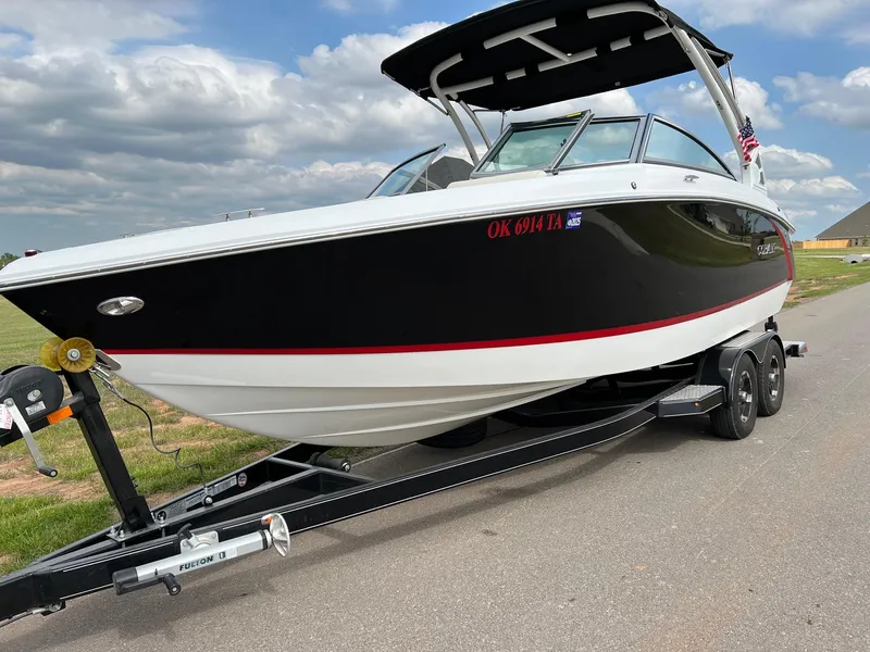 Slide: The Image of 2019 Cobalt R3 boat on a trailer, black and white exterior, parked on a road. - 2