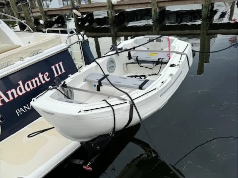 Slide: The Image of Small white boat docked beside Sabre 45 Salon Express, 2017 model. - 4