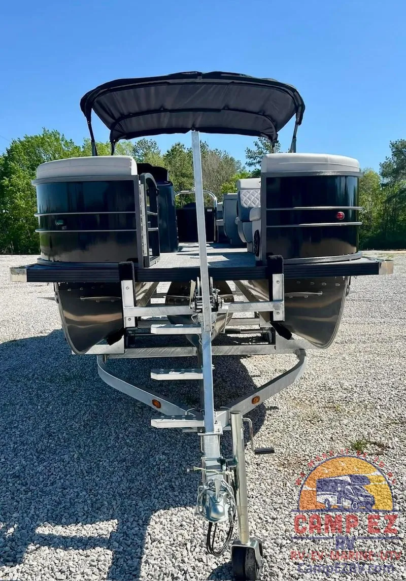 Slide: The Image of 2024 Massimo Marine P24-LTD QUAD pontoon boat on a trailer, front view. - 11