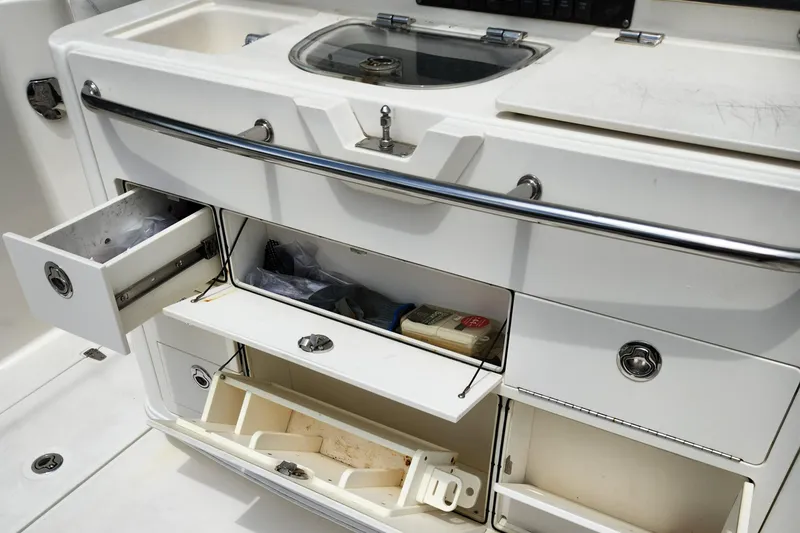 Slide: The Image of Boston Whaler 350 Outrage 2014 boat storage compartments and sink area. - 33