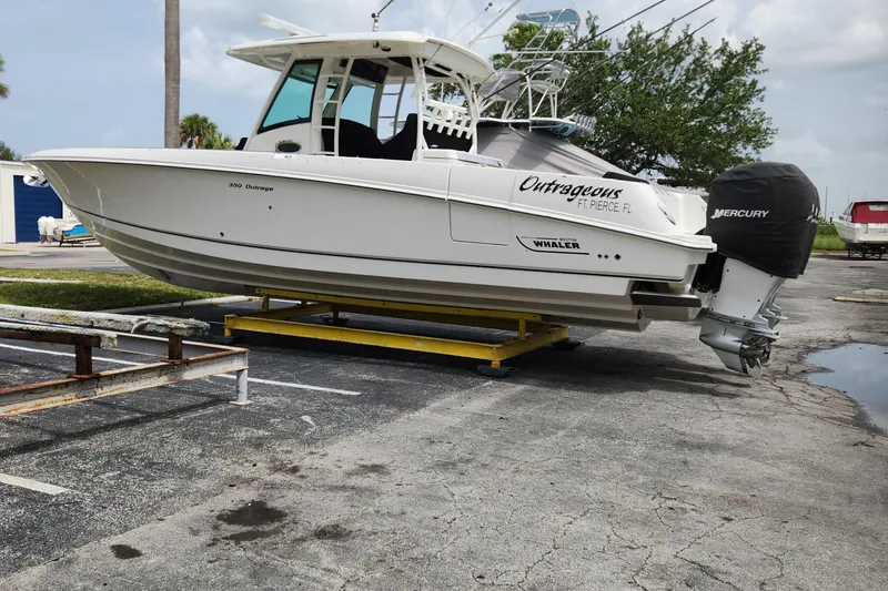 Slide: The Image of 2014 Boston Whaler 350 Outrage boat on a trailer in a parking lot. - 4