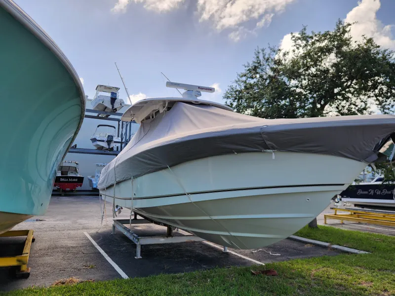 Slide: The Image of 2014 Boston Whaler 350 Outrage boat covered and parked on a trailer. - 7
