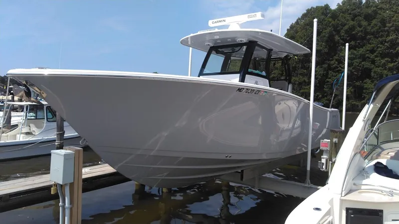Slide: The Image of 2022 Sportsman Open 302 Center Console boat docked at a marina. - 0