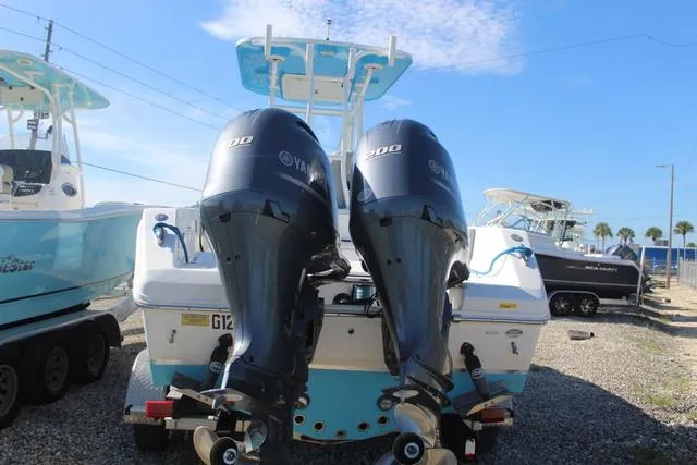 Slide: The Image of 2021 Release 240 RX boat with twin Yamaha 200 engines, docked in a marina. - 4