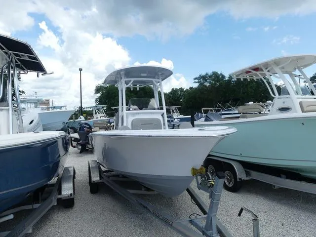 Slide: The Image of 2021 Sportsman Open 212 Cc boat on trailer in a marina. - 1