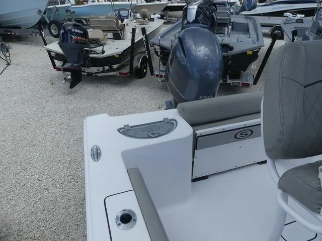 Slide: The Image of 2021 Sportsman Open 212 Cc boat, rear seating and motor, parked on gravel lot. - 14