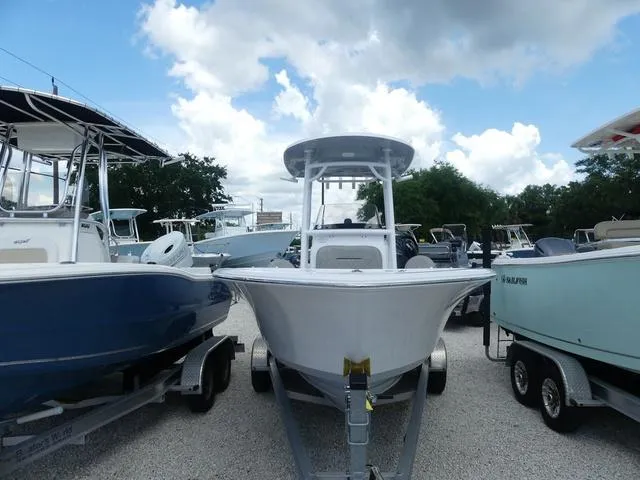 Slide: The Image of 2021 Sportsman Open 212 Cc boat on trailer, surrounded by other boats. - 2