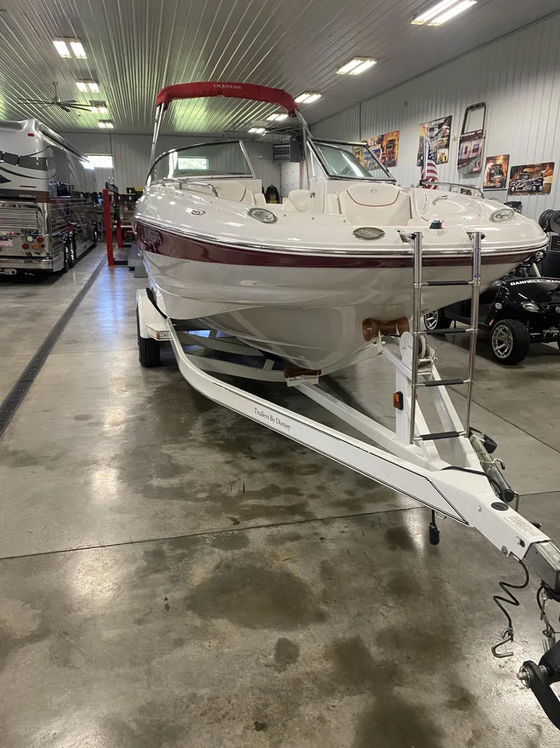 Slide: The Image of 2011 Crownline 240EX boat on trailer in indoor showroom. - 10