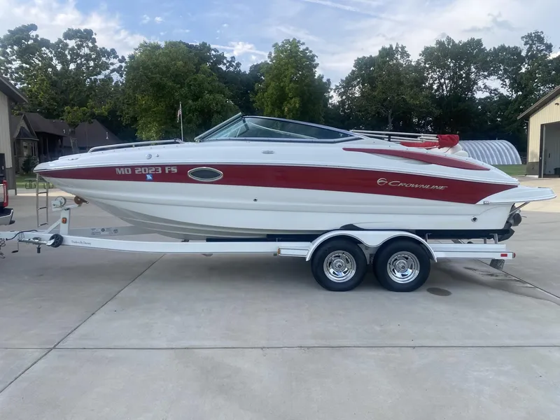 Slide: The Image of 2011 Crownline 240EX boat on trailer, parked outdoors. - 2