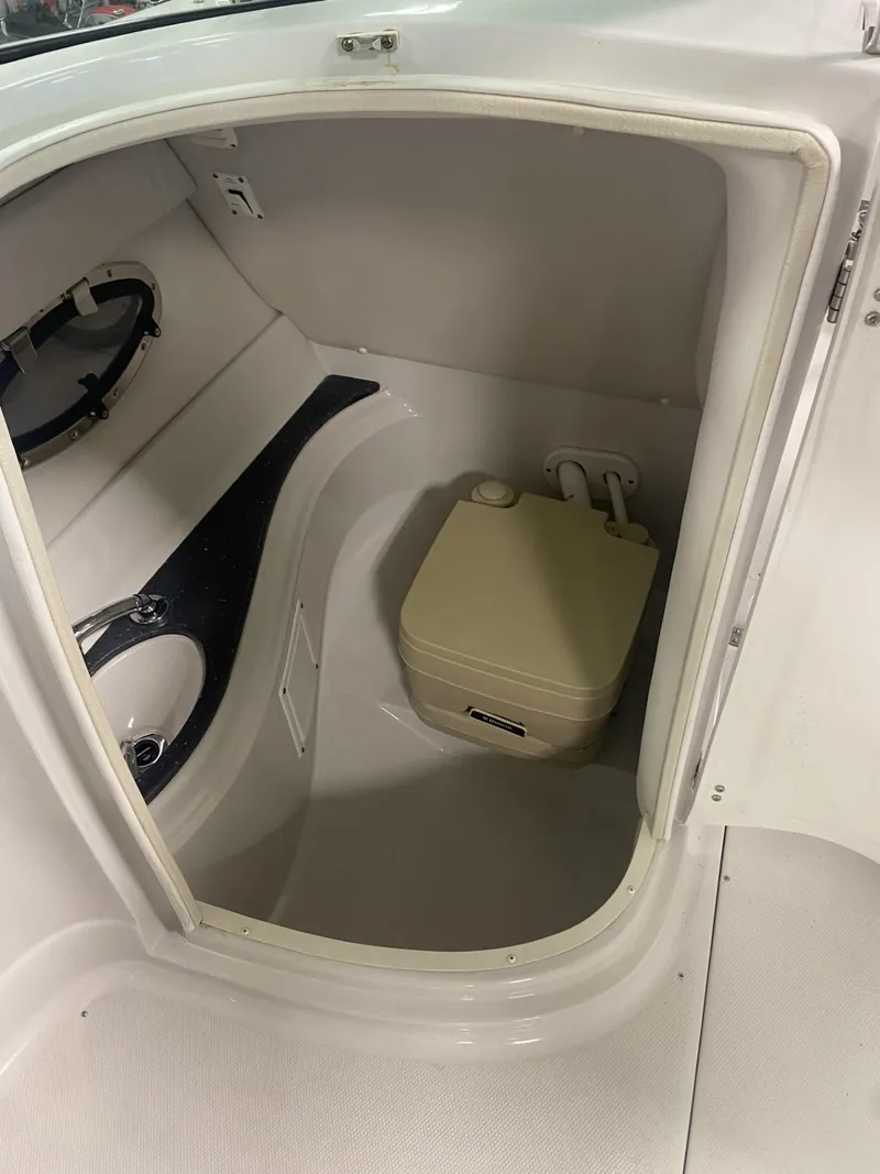 Slide: The Image of 2011 Crownline 240EX boat interior with compact portable toilet. - 5