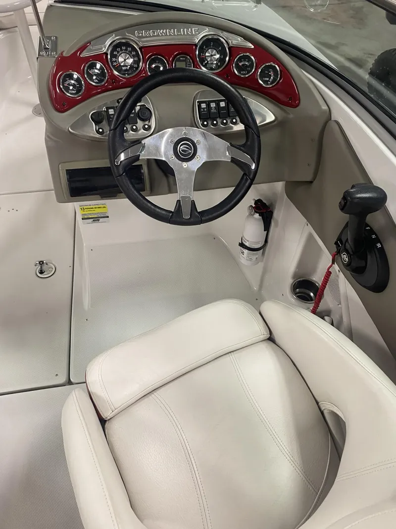 Slide: The Image of 2011 Crownline 240EX boat interior with steering wheel and dashboard controls. - 6