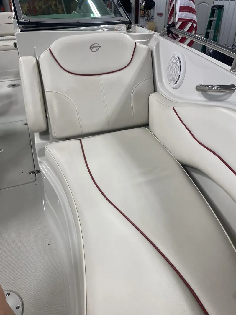 Slide: The Image of 2011 Crownline 240EX boat interior with white leather seating and red accents. - 8