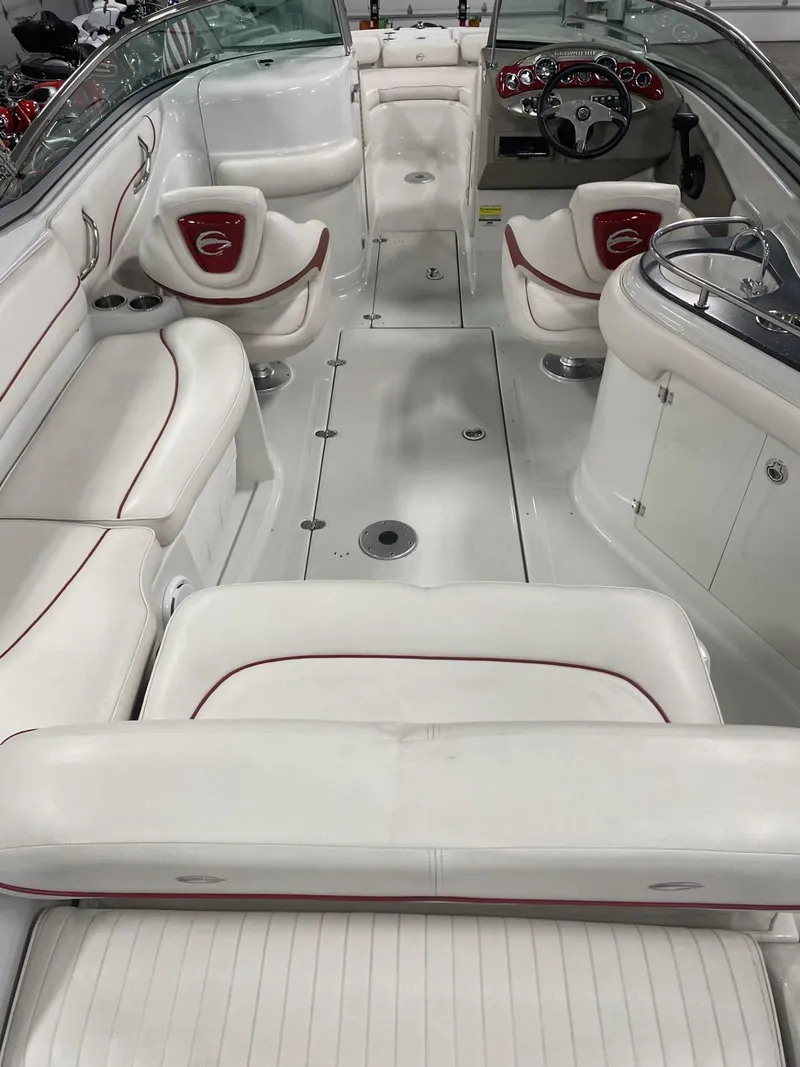 Slide: The Image of 2011 Crownline 240EX boat interior with white seating and red accents. - 9