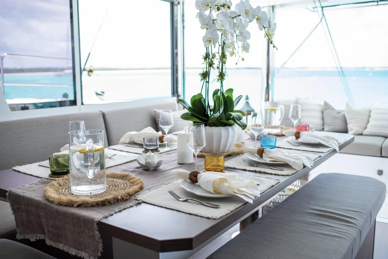Slide: The Image of Elegant dining setup on Bali 4.8 yacht, featuring orchids and ocean view, 2021 model. - 17