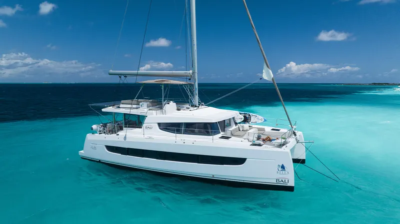 Slide: The Image of 2021 Bali 4.8 catamaran sailing on clear turquoise waters under a bright blue sky. - 6