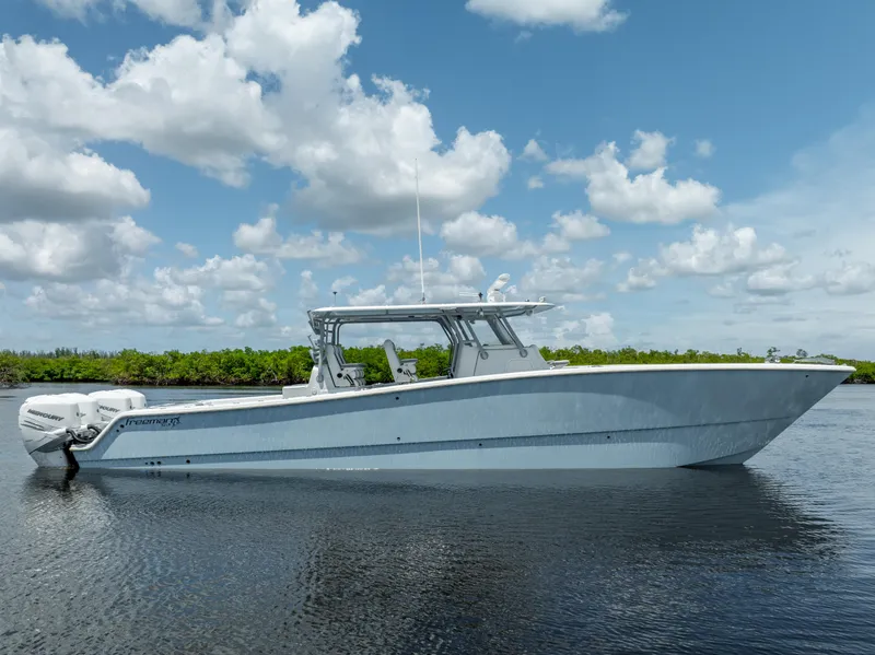 Slide: The Image of 2019 Freeman 42 LR boat on calm water with a cloudy sky background. - 13