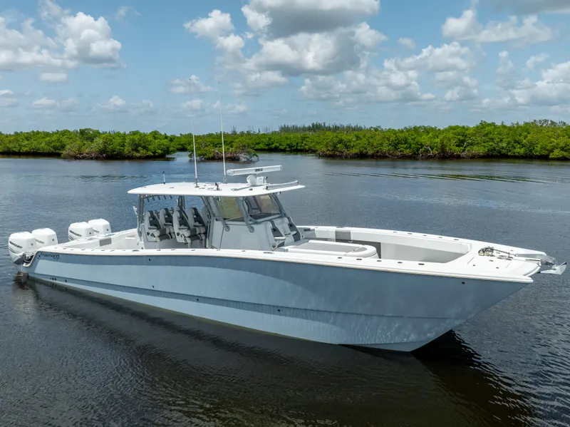 Slide: The Image of 2019 Freeman 42 LR boat on calm water with lush green background. - 14
