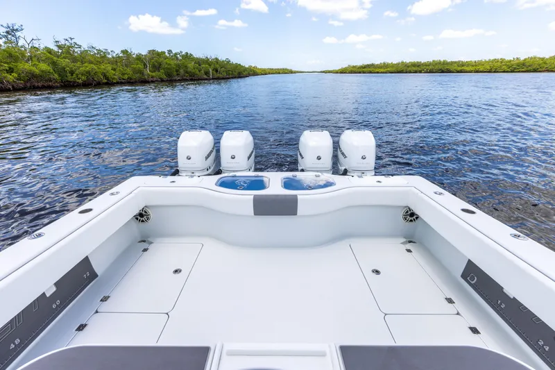 Slide: The Image of 2019 Freeman 42 LR boat with quad outboard engines on a serene waterway. - 23