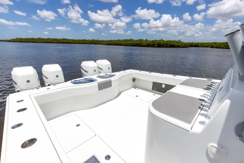 Slide: The Image of 2019 Freeman 42 LR boat with four outboard motors on a calm lake. - 24