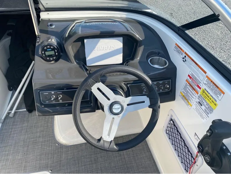 Slide: The Image of 2021 Bayliner VR6 Bowrider Outboard dashboard with steering wheel, controls, and Simrad display. - 12
