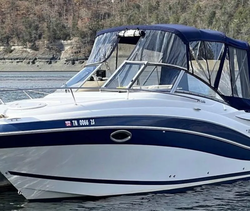 Slide: The Image of 2008 Four Winns V258 boat with blue and white exterior on a calm lake. - 1