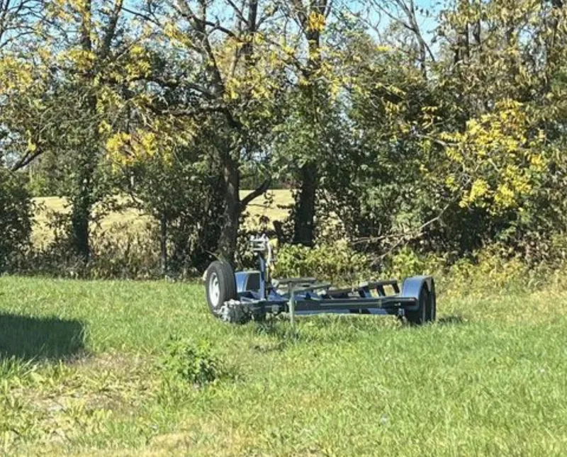 Slide: The Image of Boat trailer for 2008 Four Winns V258 in grassy field with trees in background. - 2