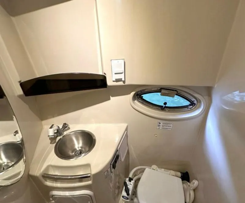 Slide: The Image of 2008 Four Winns V258 boat bathroom with sink, toilet, and porthole window. - 3