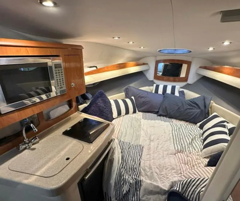 Slide: The Image of 2008 Four Winns V258 boat interior with cozy bed, microwave, and modern amenities. - 4