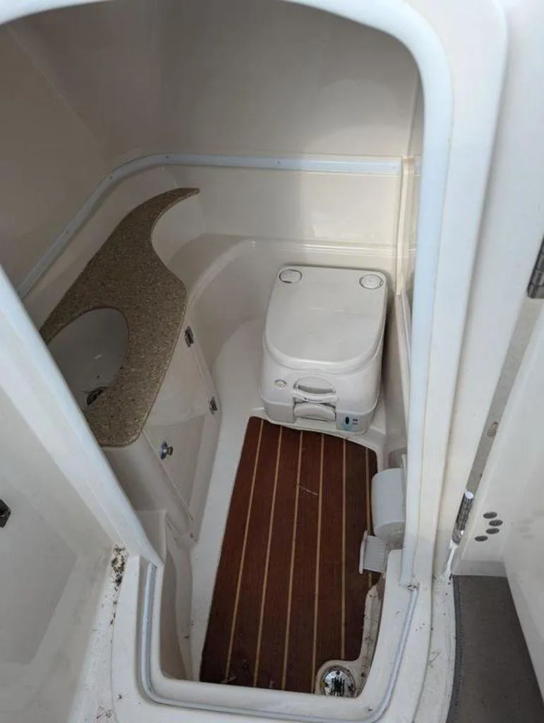 Slide: The Image of 2011 Monterey 264 FS boat bathroom with toilet, sink, and wooden floor. - 13
