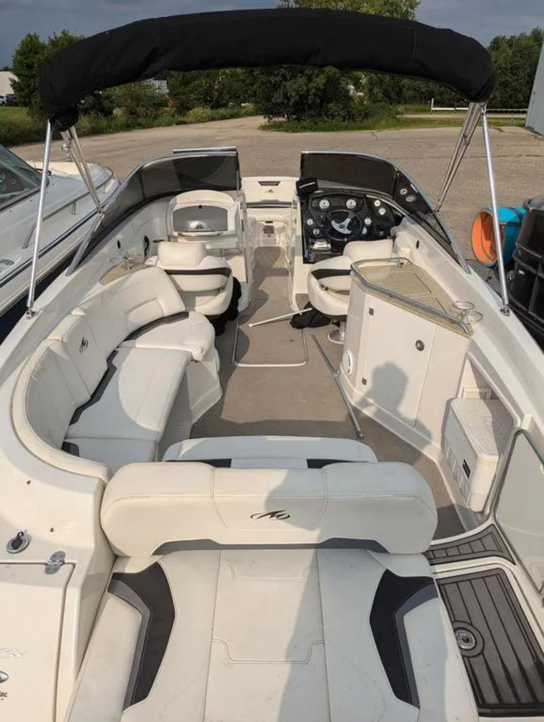 Slide: The Image of 2011 Monterey 264 FS boat interior with white seating and black canopy. - 6