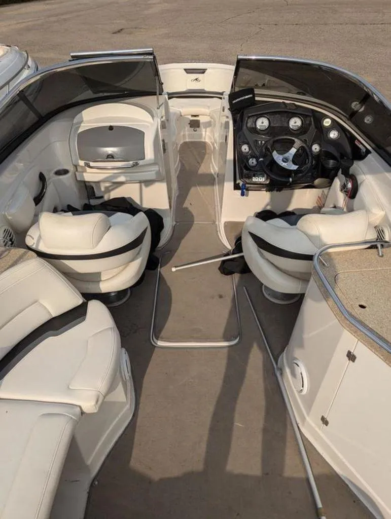 Slide: The Image of 2011 Monterey 264 FS boat interior with white seating and dashboard. - 8