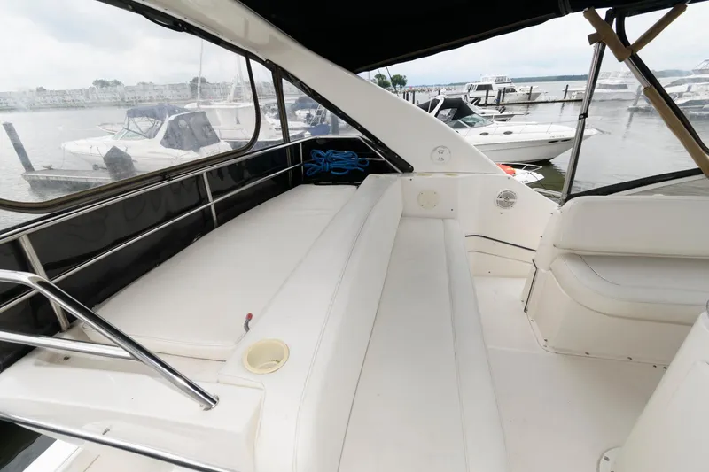 Slide: The Image of 2000 Silverton 330 Sport Bridge boat interior with white seating and marina view. - 5