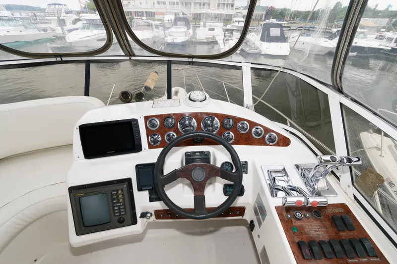 Slide: The Image of 2000 Silverton 330 Sport Bridge helm with navigation instruments and controls. - 7