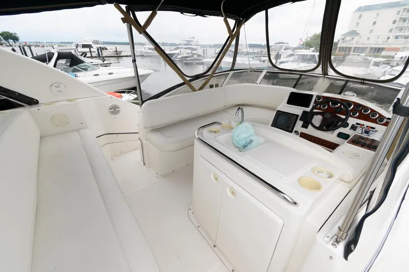 Slide: The Image of 2000 Silverton 330 Sport Bridge interior with helm, seating, and marina view. - 9