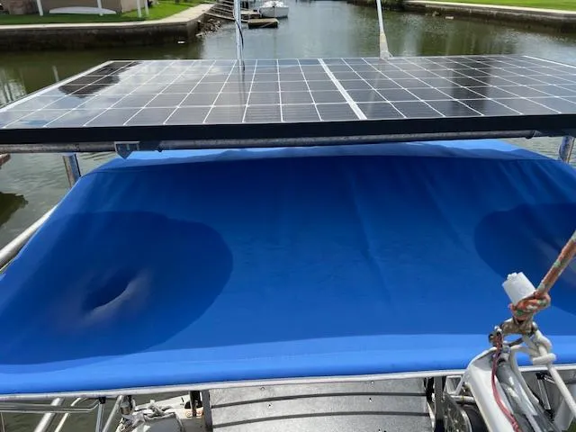 Slide: The Image of Solar panels on a 1999 Contour 34 SC boat with blue canvas cover. - 13