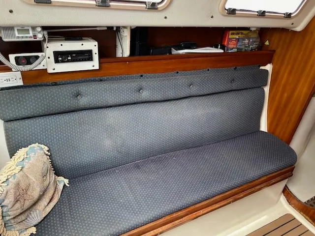 Slide: The Image of 1999 Contour 34 SC boat interior with blue cushioned seating and wooden accents. - 14