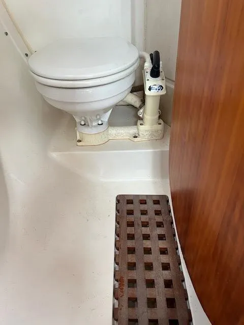 Slide: The Image of 1999 Contour 34 SC boat bathroom with toilet and wooden floor mat. - 16