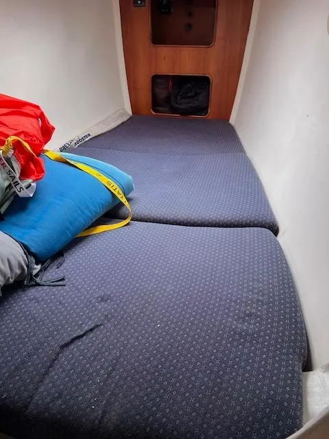 Slide: The Image of 1999 Contour 34 SC boat cabin with blue bedding and storage compartments. - 19