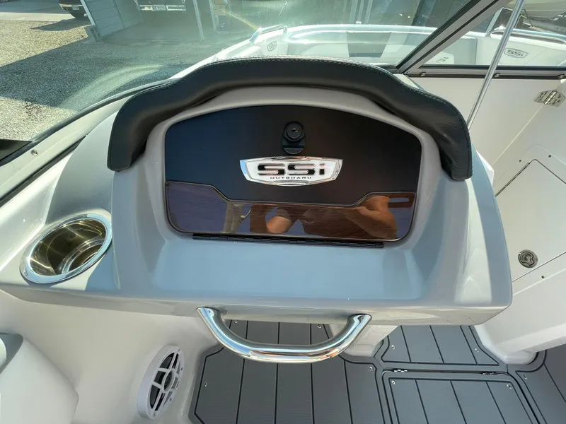 Slide: The Image of 2024 Chaparral 21 SSi OB dashboard with storage compartment and cup holder. - 19